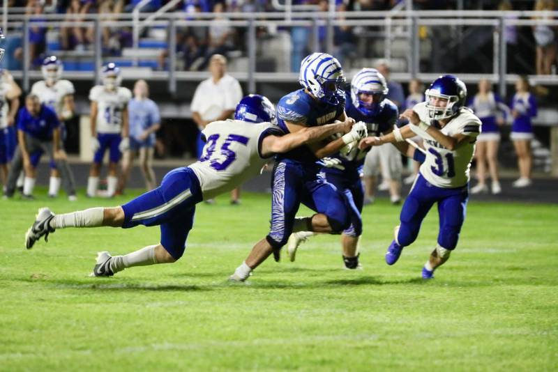 Princeton's Ace Christiansen tries to shake off Neman's Daniel Kelly and Cody McBride (31) and teammate Friday night at Bryant Field. The Tigers won 28-14.