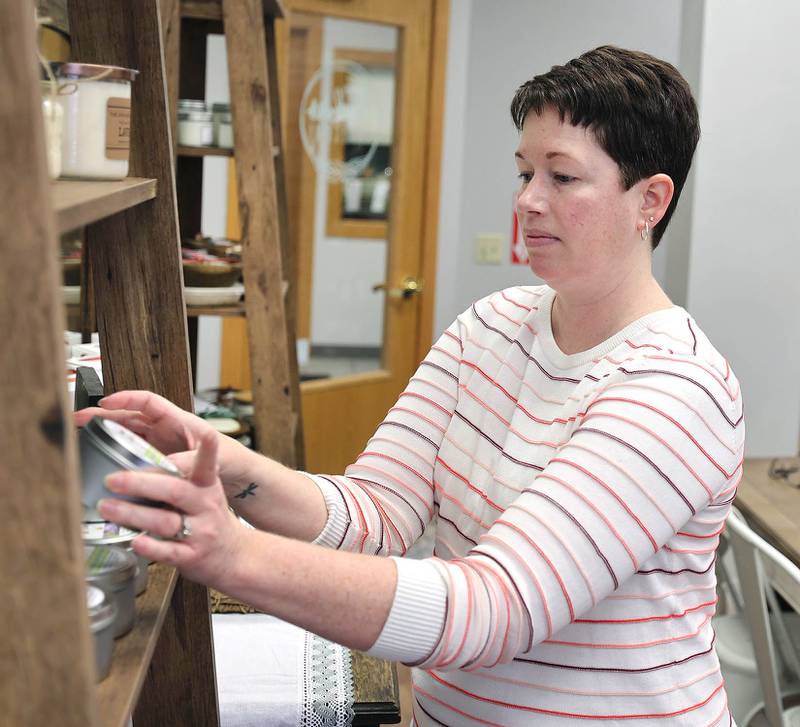 Joni Peterson, owner of 35:35 Makers Collective, adjusts items on the shelf Friday, March 18, 2022, as the store prepares to open on April 1. The store at 308 West State Street in Sycamore, features the work of local artisans.