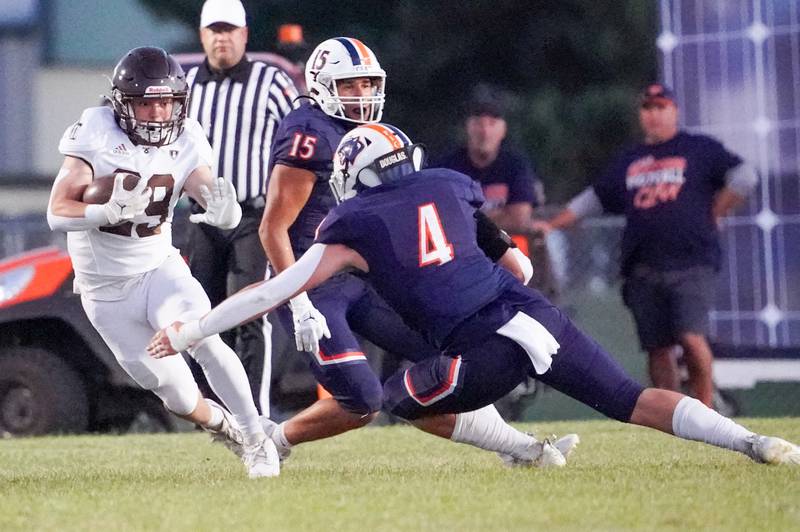 Joliet Catholic's Keegan Farnaus (29) carries the ball against Oswego’s Easton Ruby (4) during a football game at Oswego High School on Friday, Sep 6, 2024.