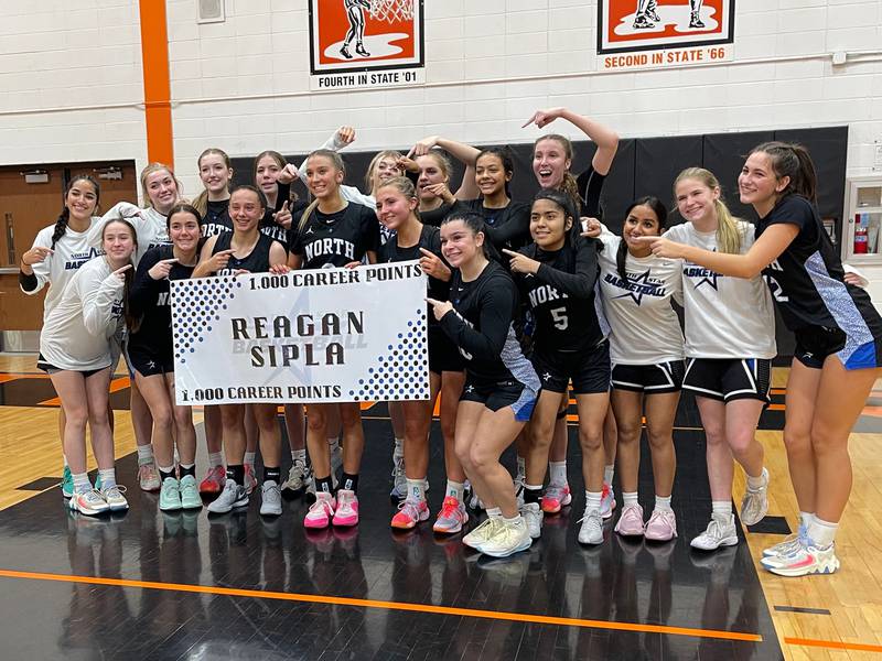 St. Charles North players pose with senior Reagan Sipla following their 57-42 win over Wheaton Warrenville South on Friday to commemorate her her 1,000th career varsity point scored.