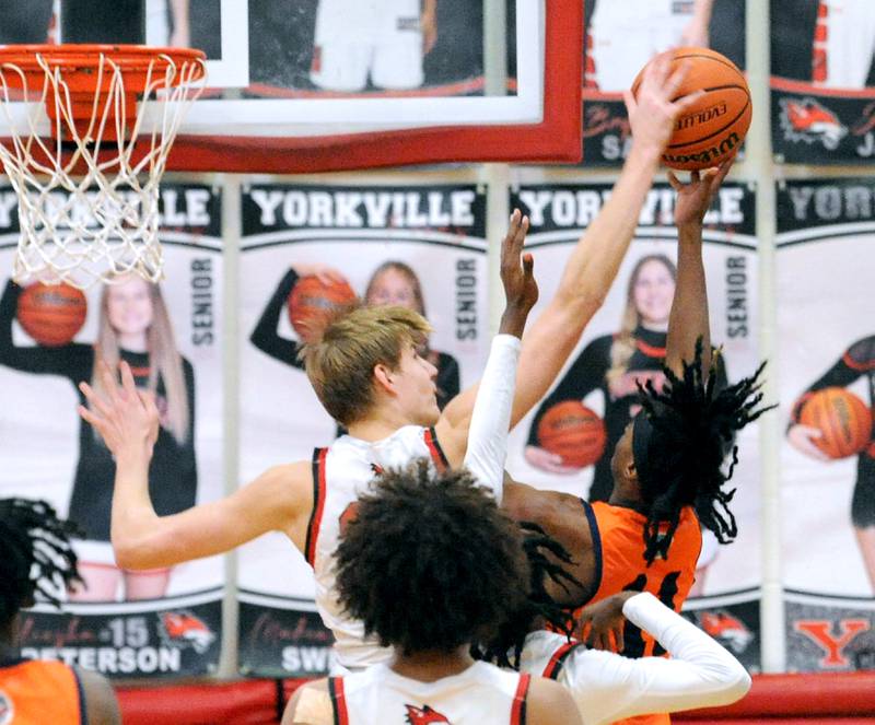 Yorkville defender Jason Jakstys blocks a shot by Romeoville's T.J. Lee (11) during a varsity basketball game at Yorkville High School on Friday, Jan. 19, 2024.