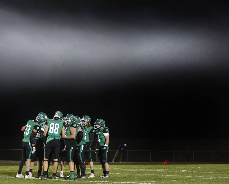 Smoke from the celebratory touchdown fireworks hang over the field as members of the Seneca offense huddle up during the Class 3A first round playoff game on Friday, Oct. 28, 2022 at Seneca.