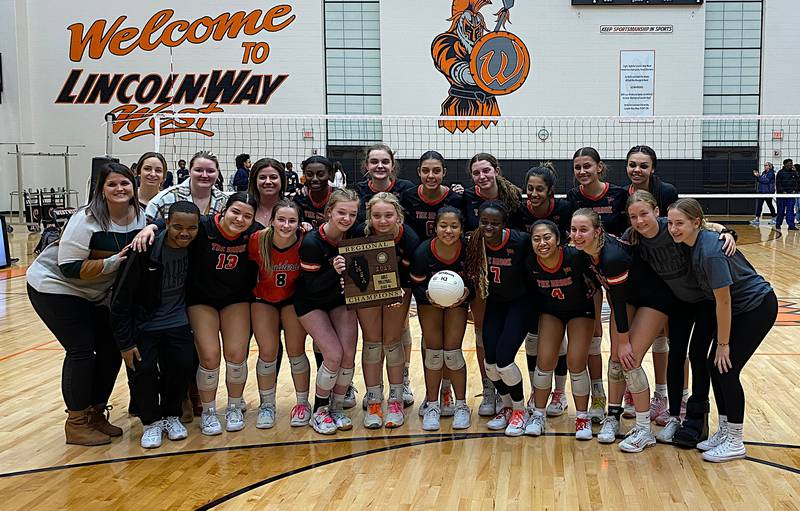 The Bolingbrook volleyball team displays the regional championship trophy after beating Romeoville in three sets for the Class 4A Lincoln-Way West Regional title.