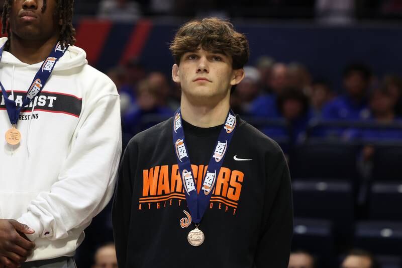 Lincoln-Way West’s Luke Siwinski stand on the podium after winning the 138-pound Class 3A fifth place match on Saturday, Feb. 17th, 2024 in Champaign.