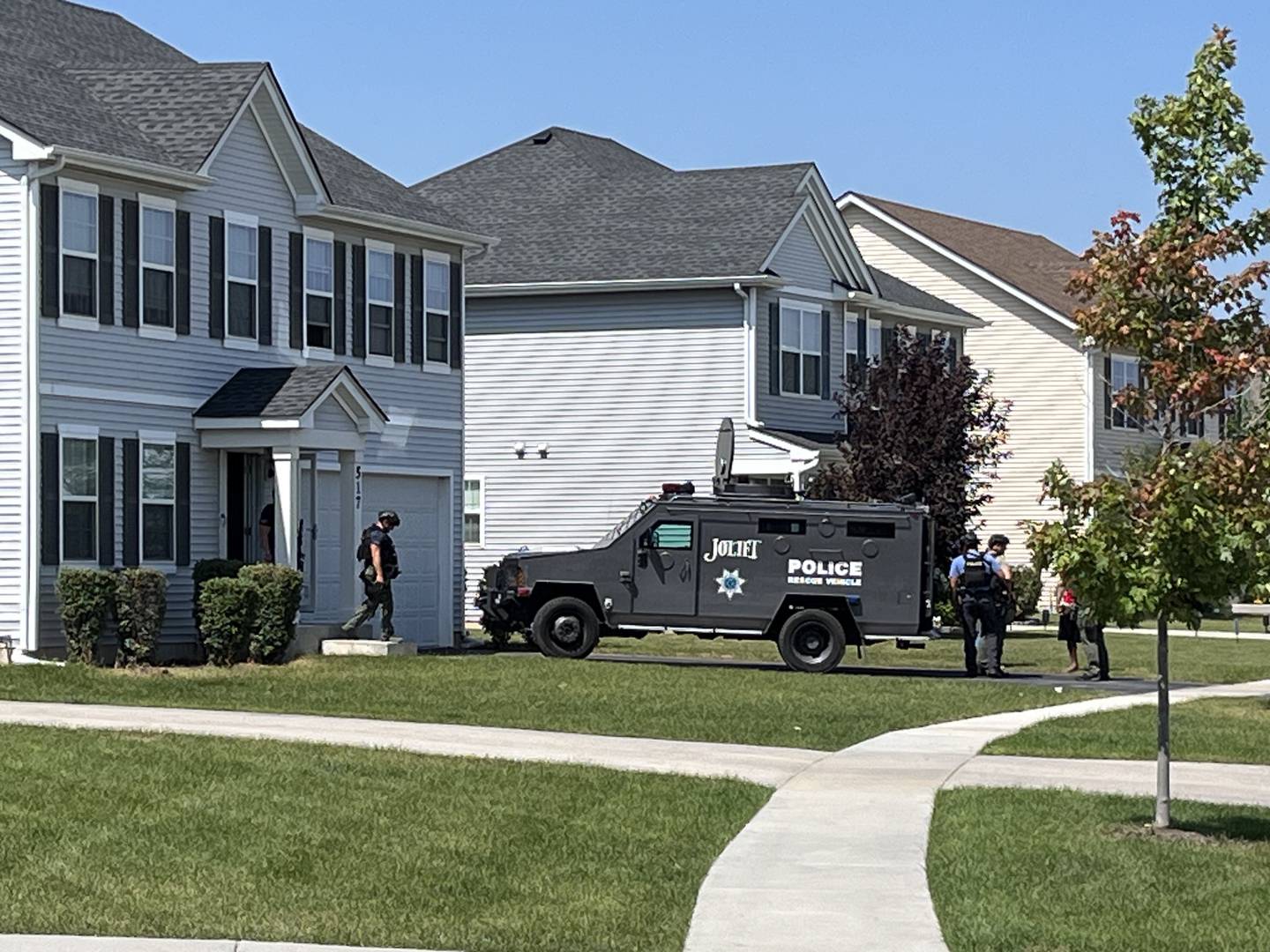 Officers leave a residence and board a rescue vehicle on Thursday, Aug. 22, 2024, near the corner of Silver Lake Street and Silver Creek Drive.