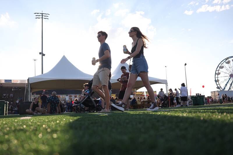 Scott Schipiour and Kelly Millies make their way to the main stage at the Taste of Joliet on Friday, June 21, 2024 at Joliet Memorial Stadium.