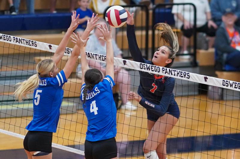 Oswego’s Hannah Herrick (7) goes up for a kill attempt against Rosary’s Clare McEniry (5) and Reese Gilla (4) during a volleyball match at Oswego High School on Tuesday, Sep 3, 2024.