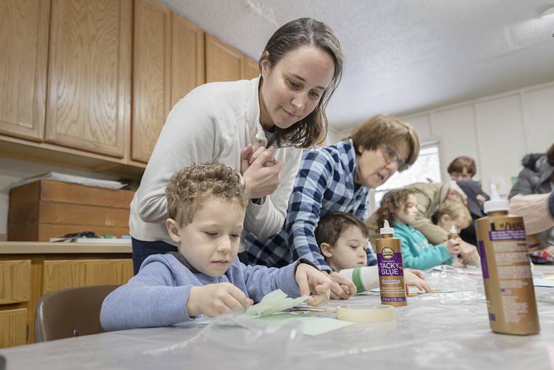 Rachel Hallstrom watches over twins Johan (left) and McClain, 4, while they make a fox craft Friday. Jan. 6, 2023.