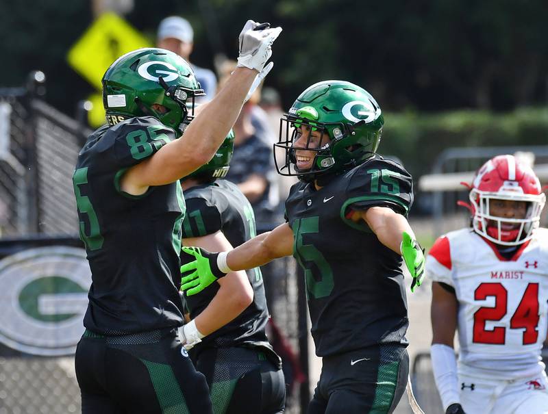 Glenbard West's Mason Ellens (15) and Ryan Segebarth celebrate Ellens' touchdown return late a game against Marist on Aug. 26, 2023 at Glenbard West High School in Glen Ellyn.