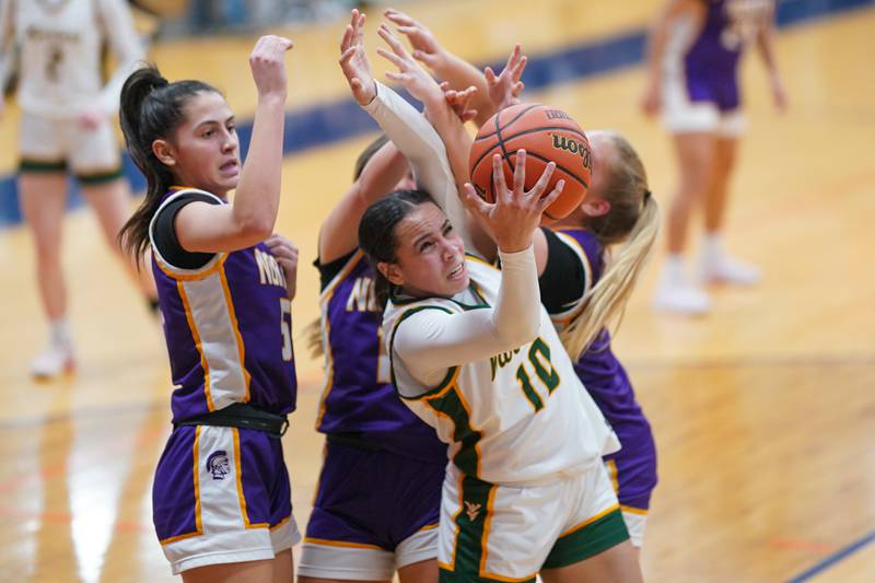 Waubonsie Valley's Danyella Mporokoso (10) rebounds the ball against three Downers Grove North defenders during a Oswego semifinal sectional 4A basketball game at Oswego High School on Tuesday, Feb 20, 2024.