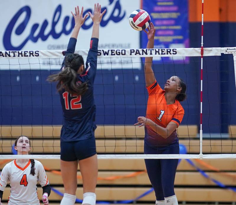 Romeoville's Eden Eyassu (1) goes up for a kill against Oswego’s Ava Flanigan (12) during a volleyball game at Oswego High School on Tuesday, Oct. 17, 2023.