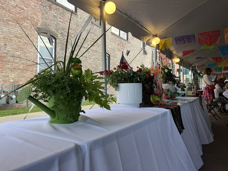 This green watering can planter filled with red superbena, lime green ipomoea batatas, yellow calibrachoa and alyssum was sold during the auction for $160.