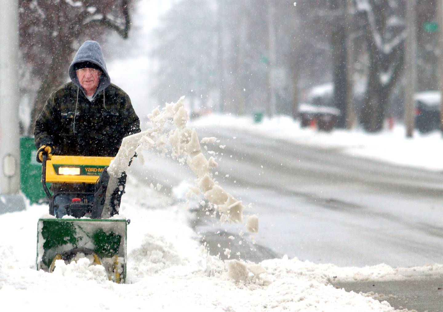 Ron Emmerich clears the driveway of his Marengo home Friday afternoon.