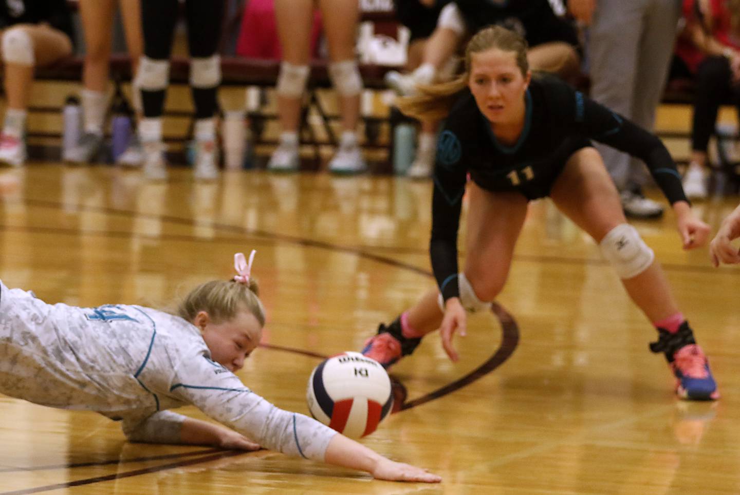 Woodstock North’s Devynn Schulze dives for the ball as her teammate, Alexis Hansen, watches during a Kishwaukee River Conference volleyball match against Richmond-Burton Wednesday, Oct.11, 2023, at Richmond-Burton Community High School.