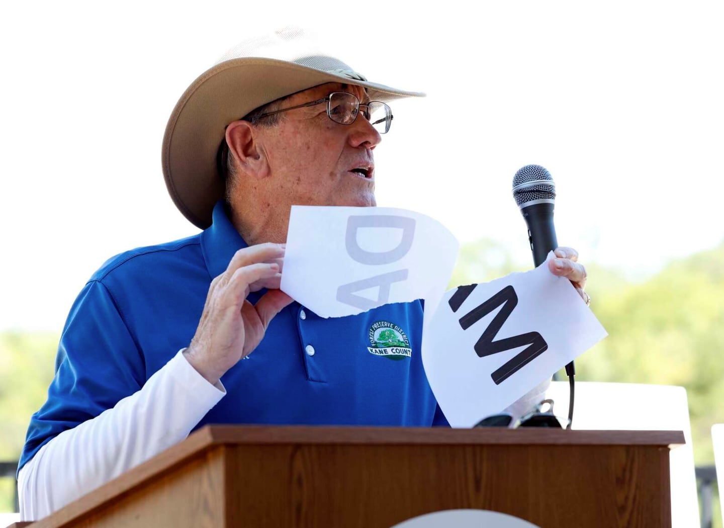 Kane County Forest Preserve Commission President Chris Kious rips a piece of paper with the word “dam” on it Wednesday to symbolize the removal of the Carpentersville Dam.