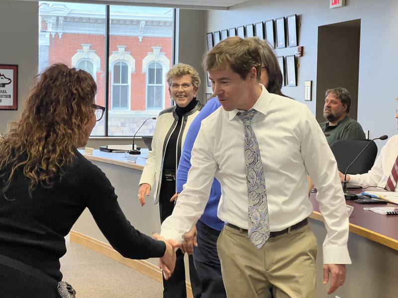 Fourth Ward Alderperson Ben Bumpus shakes hands with Anna Wilhelmi, the leader of the Dekalb County Democratic Party after being sworn-in as a Sycamore City Council member on May 1, 2023.