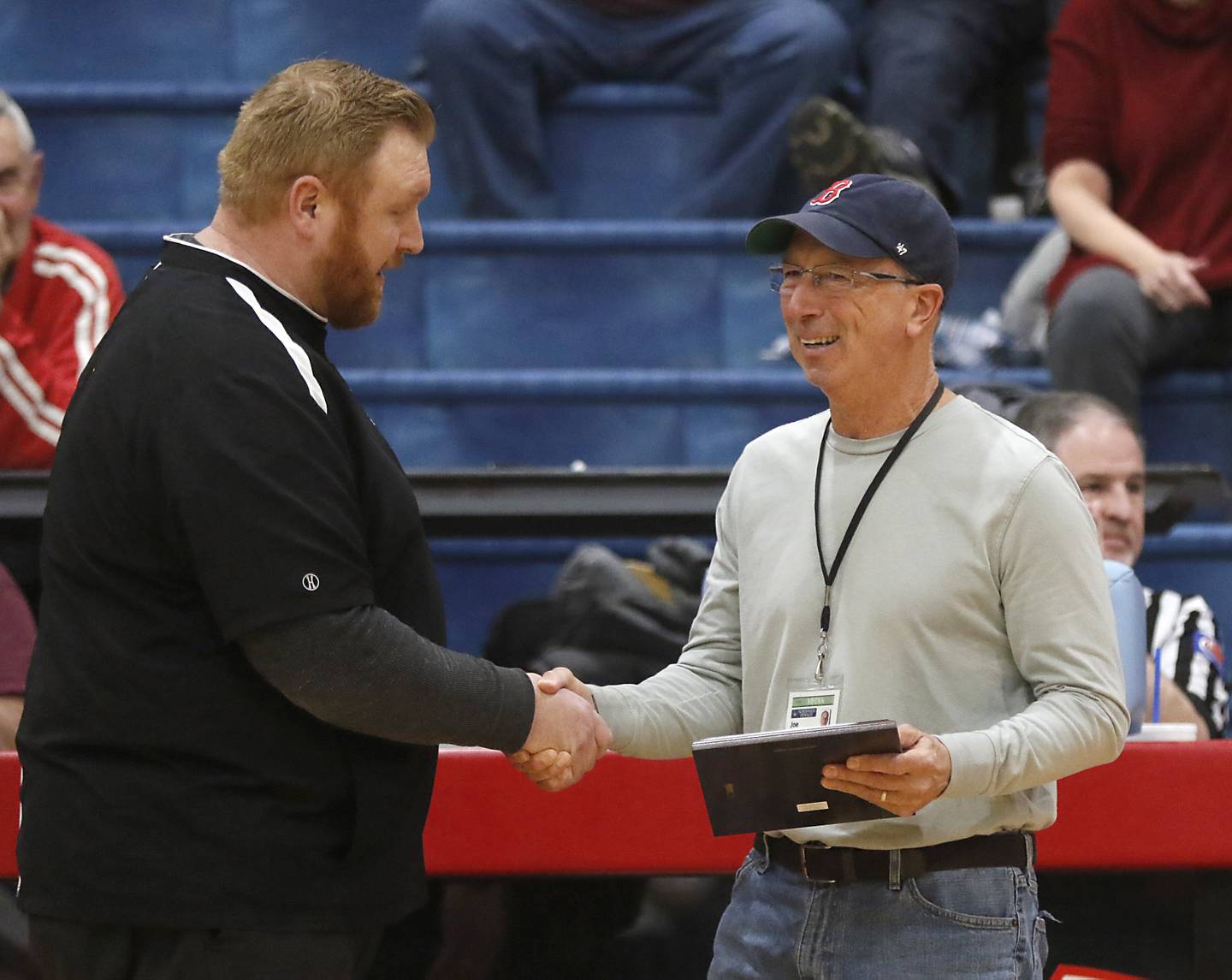 Marin Central athletic director Cody O'Neill  present Northwest Herald sports reporter Joe Stevenson with a plaque during a nononference boys basketball game between Marengo and Marian Central on Tuesday, Feb.13, 2024, at Marian Central High School. Stevenson is retiring after working for Shaw Media for 35 years.