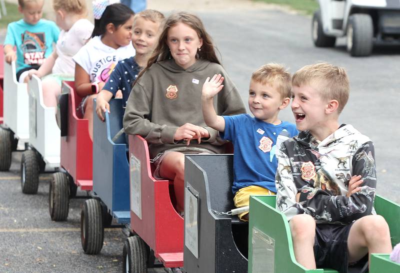 Kids wave to their families as they set out on a train ride Saturday, July 16, 2022, on the grounds of the Waterman Lions Summerfest and Antique Tractor and Truck Show at Waterman Lions Club Park.