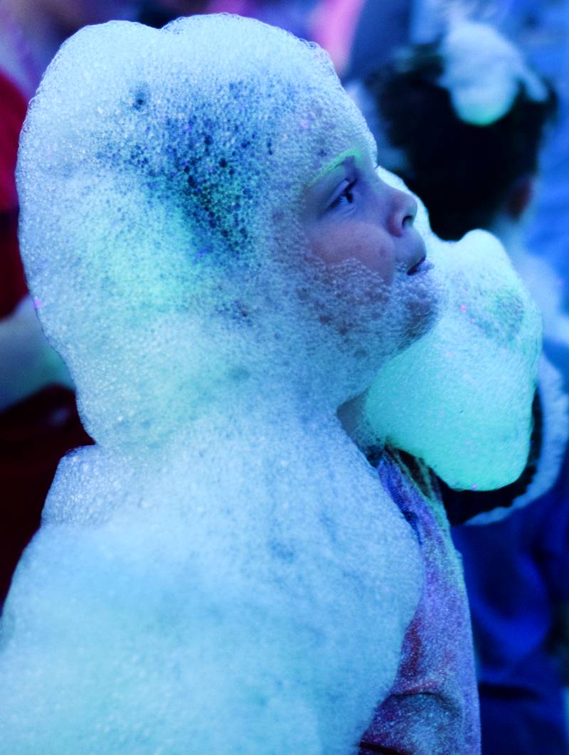 Kids participate in Driving Cap Entertainment's UV Glow Foam Party during Newton Fest on June 9 in Maytag Park in Newton.