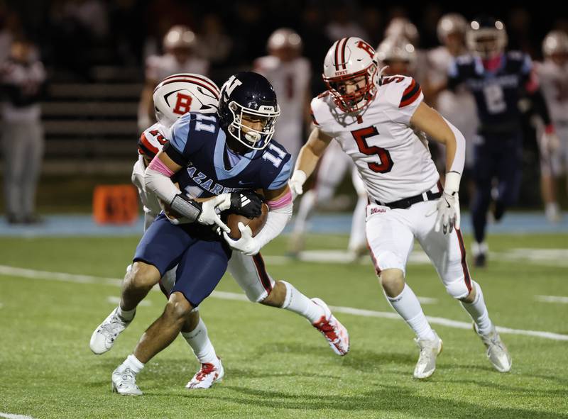 Nazareth's James Penley (11) tries to break free of the Benet defense during the varsity football game between Benet and Nazareth academies on Friday, Oct. 18, 2024 in La Grange Park.