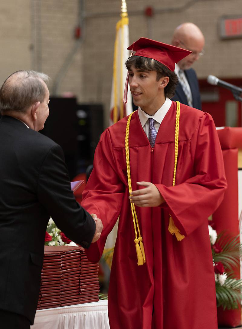Jack Henson shakes hands with board president Don Harris on Friday, May 24, 2024, during Ottawa High School's graduation ceremony.
