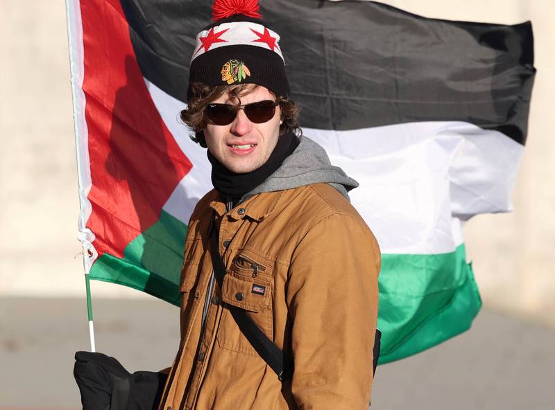 Nicholas McKay, 24, a junior at Northern Illinois University, holds a Palestinian flag during a protest against the Israel–Hamas war Thursday, Feb. 29, 2024, outside the Holmes Student Center at Northern Illinois University in DeKalb.