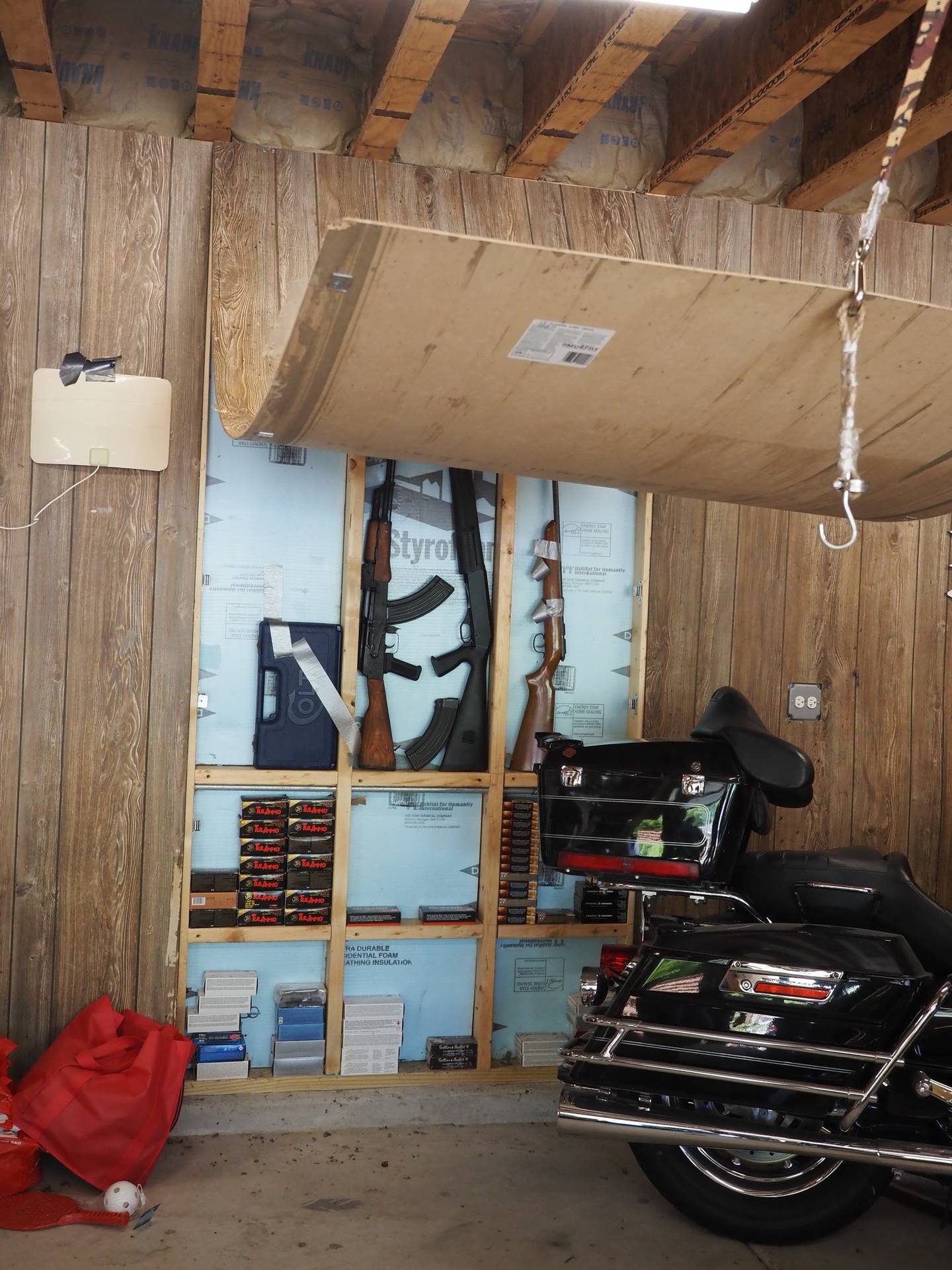 Multiple guns were uncovered behind a hidden panel inside John Shadbar's garage during a police search of the property.