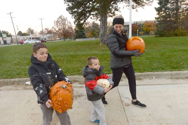 Kelsey Warner and her two boys, Benjamin 3, and Joseph 7, carry their Jack-O-Lanterns to the fire tower during the Byron Fire Department's Pumpkin Smashing Event on Wednesday, Nov. 1, 2023.