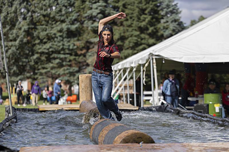 Brett Wells eyes the finish during the boom run at the Lumberjack show Saturday, Oct. 7, 2023. Competitors try to make it across and back the floating logs in 9 seconds.