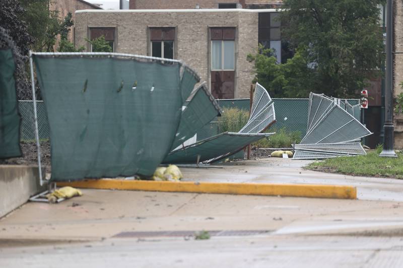 The fence around the site where the old Will County courthouse once was is blown down after a storm blew through Joliet Sunday morning, July 14, 2024.