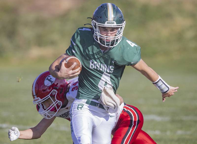 St. Bede quarterback John Brady sneaks by Forreston's Jace Engbert (34) during a carry in the Class 1A first round playoff game on Saturday, Oct. 29, 2022 at the Academy in Peru.