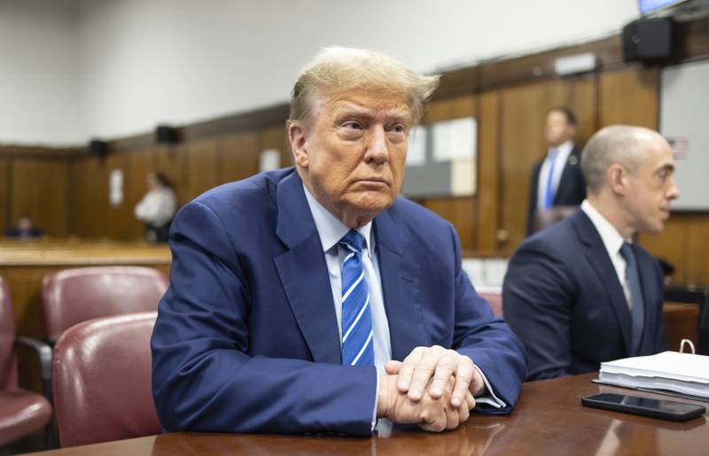 FILE - Former President Donald Trump awaits the start of proceedings on the second day of jury selection at Manhattan criminal court, April 16, 2024, in New York.  Manhattan prosecutors are balking at Donald Trump efforts to delay post-trial decisions in his New York hush money criminal case as he seeks to have a federal court intervene and potentially overturn his felony conviction. They lodged their objections in a letter Tuesday to the trial judge but said they could be OK with postponing the ex-president’s Sept. 18 sentencing.  (Justin Lane/Pool Photo via AP)