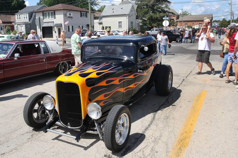 A car heads down Elm Street looking for its parking spot during the Fizz Ehrler Memorial Turning Back Time Car Show Sunday, July 30, 2023, in downtown Sycamore.