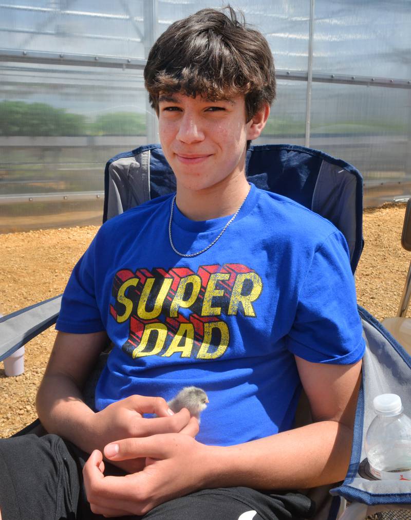 "Super Dad" Eli Perez, a Polo FFA member, holds a chick at the Polo High School's FFA Petting Zoo on Friday, May 10, 2024. FFA members and high school agriculture students brought animals and farm machinery to this year's event. The chicks belonged to FFA Adviser and Ag Teacher Stephanie Schultz.