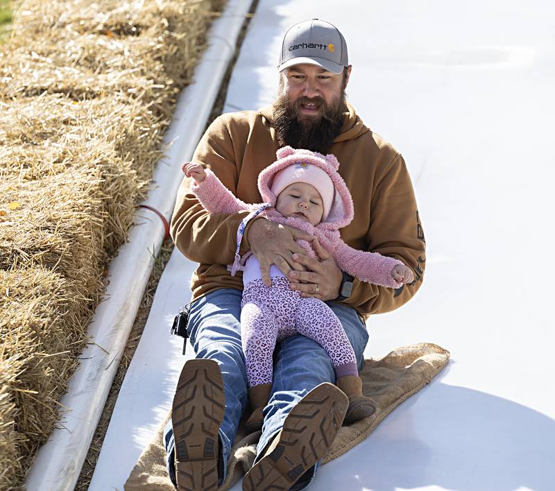 Dennis McCormick holds onto Esmae, 1, as they go down the slide at Selmi’s Saturday, Oct. 7, 2023.