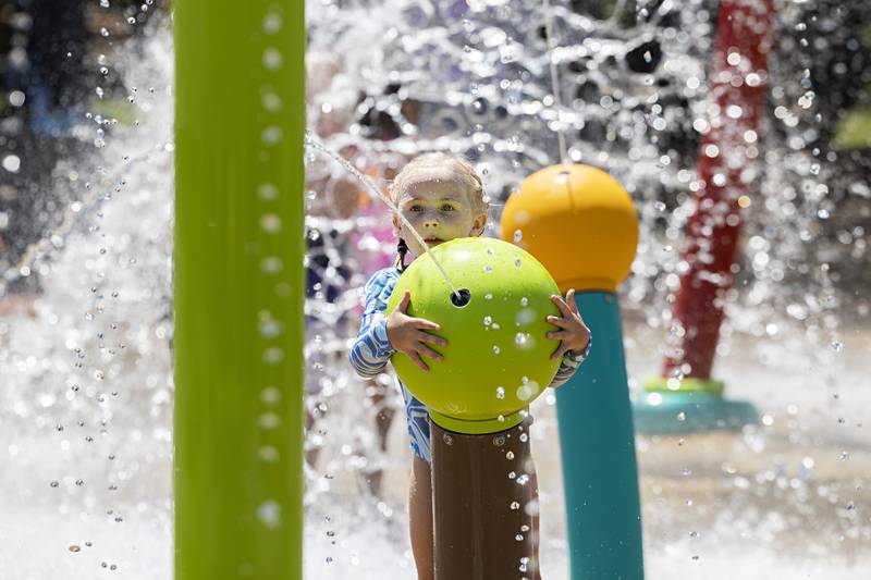 Brielle Schmidt, 4, of Tiskilwa fires off a giant water gun Thursday, July 27, 2023 at the Dixon splash pad.