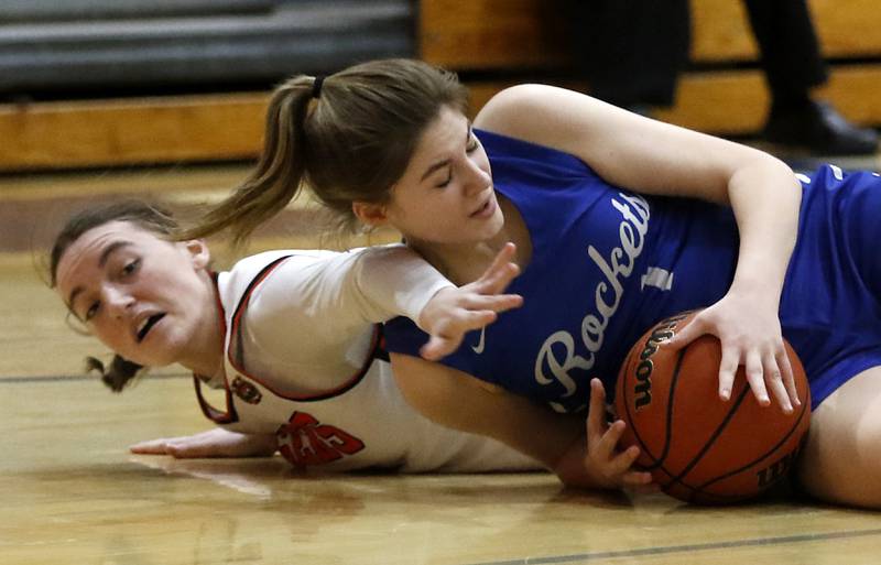 Crystal Lake Central's Katie Hamill battles for a loos ball with Burlington Central's Emersyn Fry during the IHSA Class 3A Woodstock Regional Championship girls basketball game on Thursday, Feb. 15, 2024, at Woodstock High School.