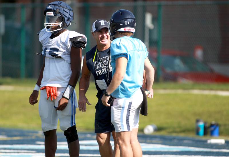 Nazareth Head Coach Tim Racki (center) talks with players Lesroy Tittle (left) and Logan Malachuk during a practice on Monday, Aug. 19, 2024 at the La Grange Park School.