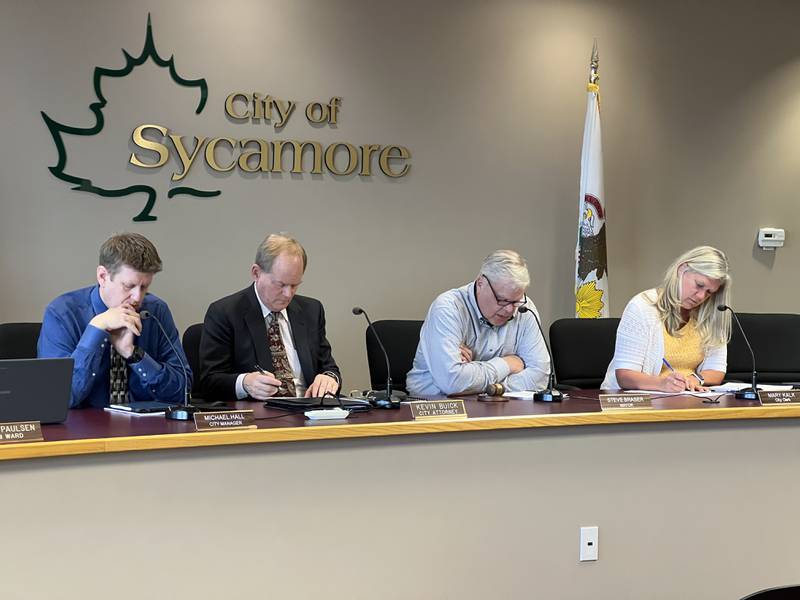Sycamore City officials –including City Manager Michael Hall, City Attorney Kevin Buick, Mayor Steve Braser and City Clerk Mary Kalk – look over the agenda at the beginning a City Council meeting on May 6, 2024.