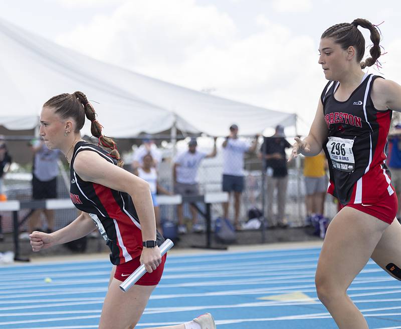 Forreston’s Bree Schneiderman takes the baton from Elsa Monaco in the 1A 4x100 Saturday, May 18, 2024 at the IHSA girls state track meet in Charleston.