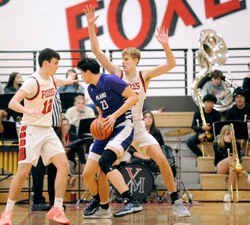 Plano's Isaiah Martinez (23) battles Yorkville defender Jason Jakstys during a varsity basketball game at Yorkville High School on Tuesday, Dec. 19, 2023.