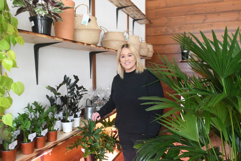 Ashley Ruch stands by some her plants at her new business Grungy Roots in Grand Detour.