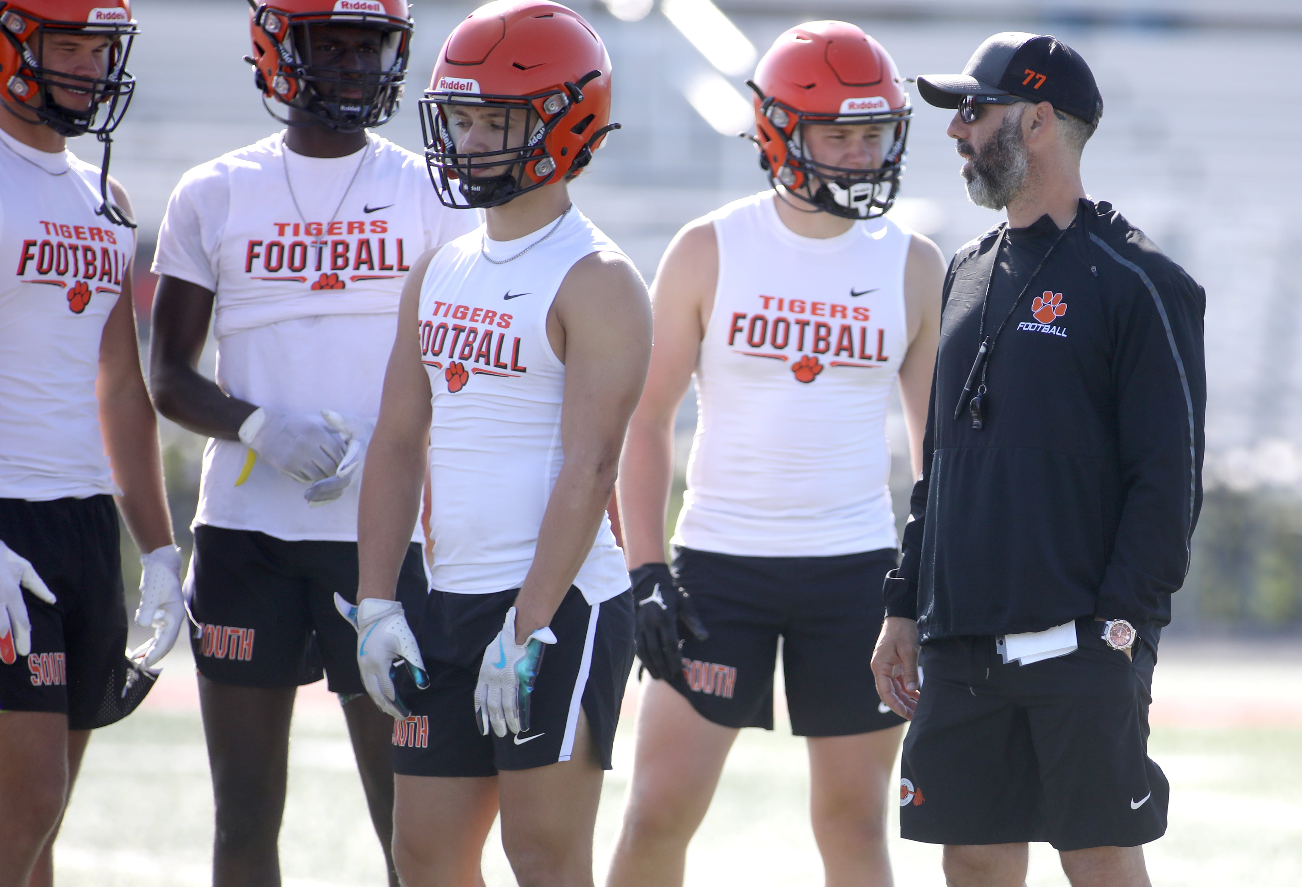 Wheaton Warrenville South Head Coach Sean Norris (right) talks to some of his team during a 7-on-7 tournament at Batavia High School on Thursday, July 18, 2024.