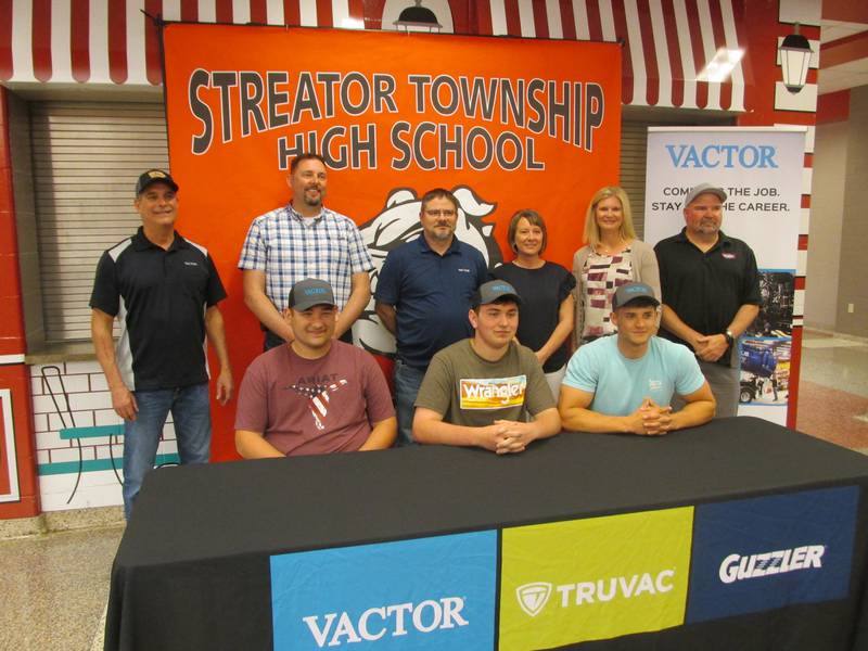 Streator High School students (Left to right, front row) Carson Trenor, Hayden Wolfe and Chase Hamara accept a full-time position at Vactor Manufacturing with (left to right, back) Tim Hackathorn, paint supervisor at Vactor Manufacturing; Doug Johnson, plant manager; Matt Bouley, production manager; Rene Barr, human resources generalist; Katie Muntz, human resources manager; and Mike Starjak, assembly supervisor.