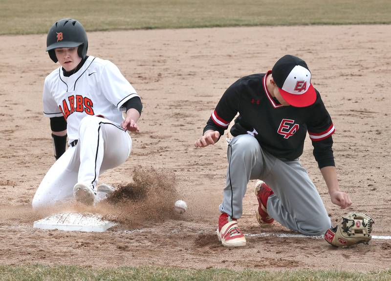 DeKalb pinch runner Jonah Keck slides safely into third as the ball gets by East Aurora’s Sammy Gonzalez during their game Wednesday, March 13, 2024, at DeKalb High School.