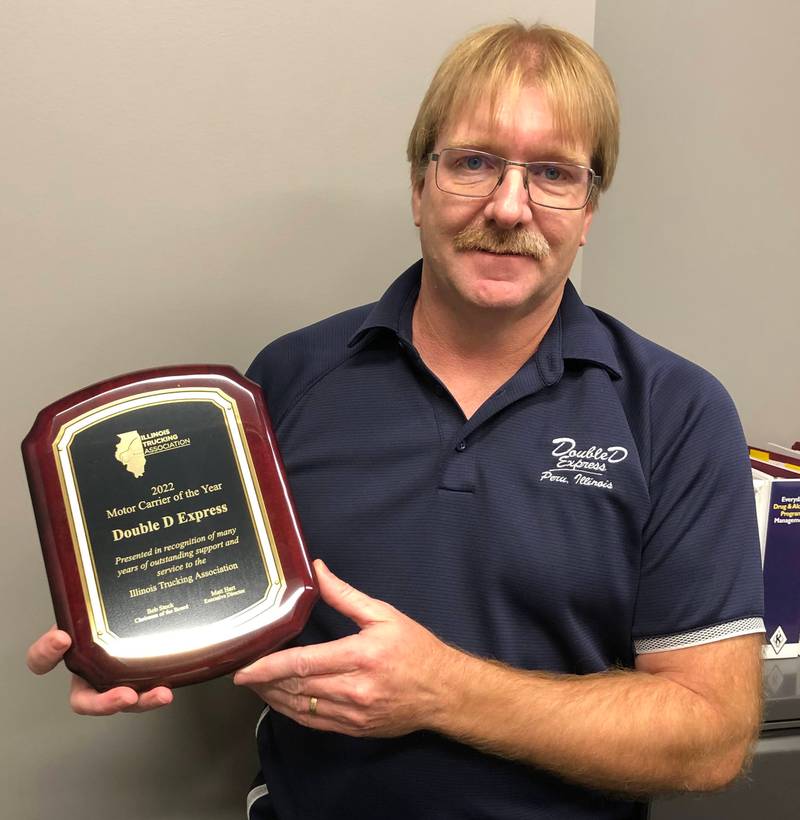 Safety Manager Alan Detmers of Double D Express in Peru poses with an award granted to the company for the Illinois Trucking Association's Motor Carrier of the Year.