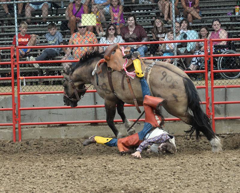 Jacob Beyer of Texas, loses his boot in his stirrup as he is thrown from a bucking bronco in the saddle broncs competition in the afternoon session of the Big Hat Rodeo at the Ogle County Fair on Friday, Aug. 4, 2023.