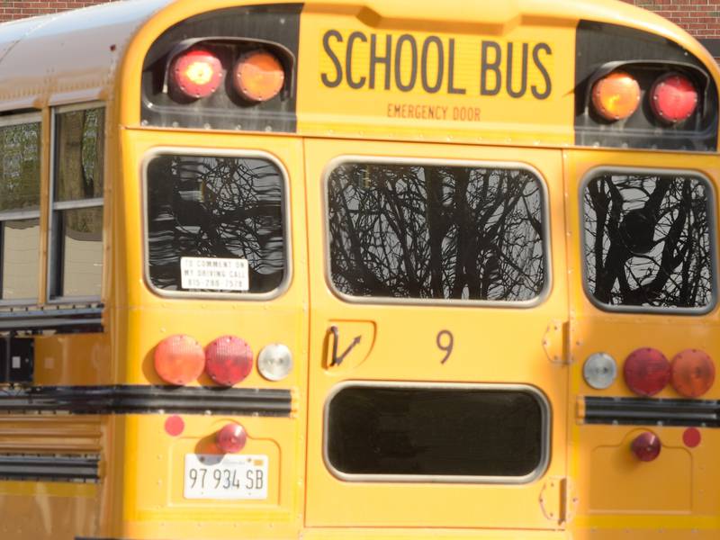 Students exit a school bus as they enter Hinckley-Big Rock Middle School that is part of School District 429 on Tuesday, April 27, 2021.