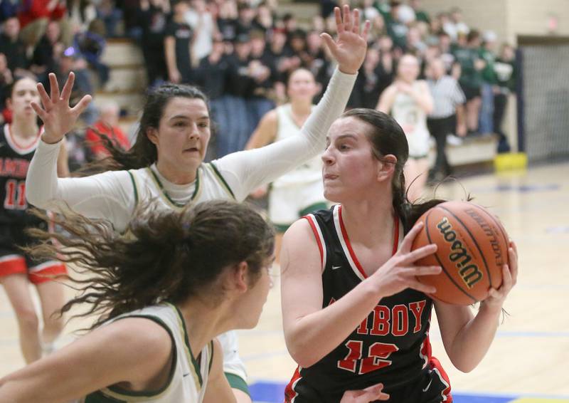 Amboy's Addison Pertell gets stuck in the lane as St. Bede's Lily Bosnich and Ali Bosnich defend during the Class 1A Regional final game on Friday, Feb. 16, 2024 at Marquette High School.
