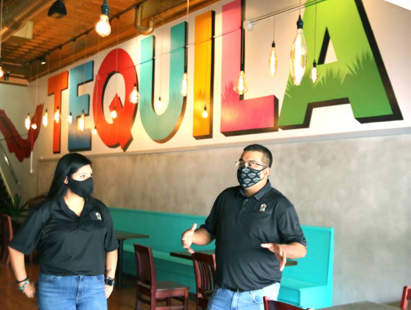 Co-owners Olivia Pacheco and Rudy Hernandez talk under the large tequila painting Thursday at the new El Jimador Mexican Grill, 260 E. Lincoln Highway in DeKalb. The restaurant is planning to open in the last weekend in September.